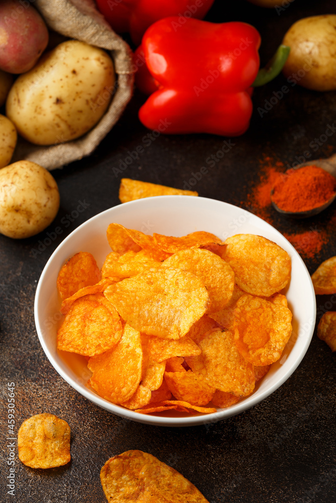 Paprika Potato Chips in white bowl on rustic background