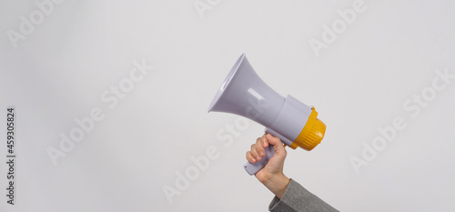 Hand is hold megaphone and wear grey suit on white background..