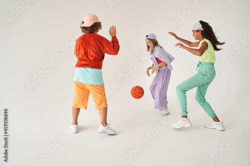 Multiracial friends play basketball game in studio