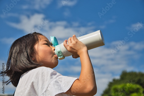 水筒で、水分補給する女の子 photo