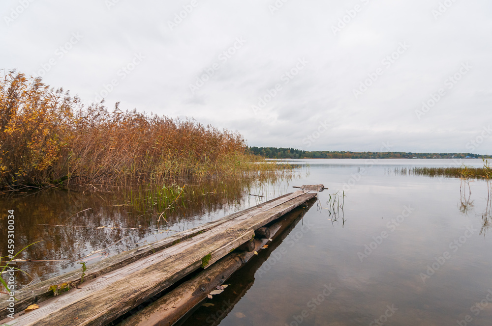 Naklejka premium Beautiful landscape with a view of the lake and wooden footbridge, autumn