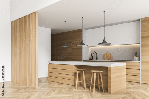 Corner view of modern white kitchen with wooden materials