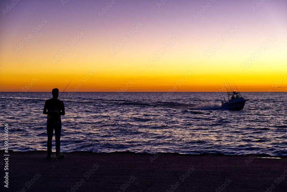 Lake Michigan fisherman & returning boat at dusk