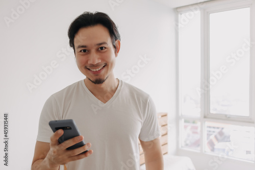 Happy and smile face of Asian man using smartphone.