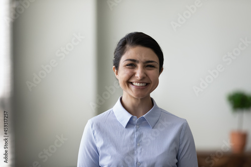 Head shot portrait of happy young Indian business leader, self employed professional, office worker, employee. Profile picture of millennial mixed raced business woman smiling at camera