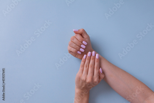 Closeup of hands of a young woman with pink manicure.