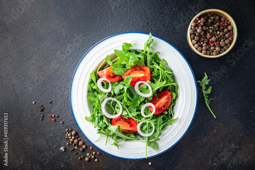arugula and tomato salad vegetable in a plate fresh portion ready to eat meal snack on the table copy space food background rustic. top view keto or paleo diet veggie vegan or vegetarian food