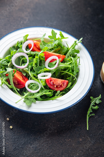 arugula and tomato salad vegetable in a plate fresh portion ready to eat meal snack on the table copy space food background rustic. top view keto or paleo diet veggie vegan or vegetarian food