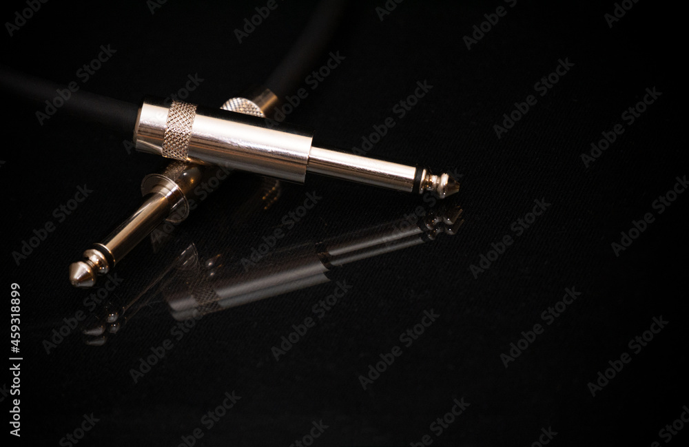 Two silver TRS connectors for the analog audio signal are placed against a black background. Professional jack connectors for sound equipment. Audiophile technologies concept. Two silver TRS connectors for the analog audio signal are placed against a black background. Professional jack connectors for sound equipment. Audiophile technologies concept.