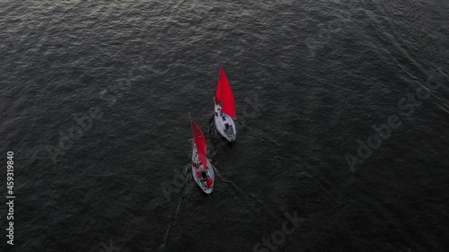 Aerial view of the two ships with red sails and the hydro cycle on the river in the summer 