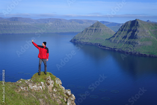 Tourist takes a selfie on the background of the Funningur fjord, Faroe Islands © Oleksandr Kotenko