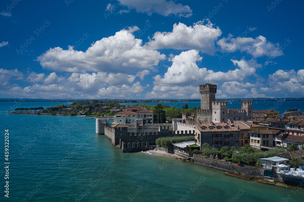 Flag of Italy on the towers of the castle on Lake Garda. Top view of the 13th century castle. Aerial panorama of Sirmione castle, Lake Garda, Italy. Italian castles Scaligero on the water.