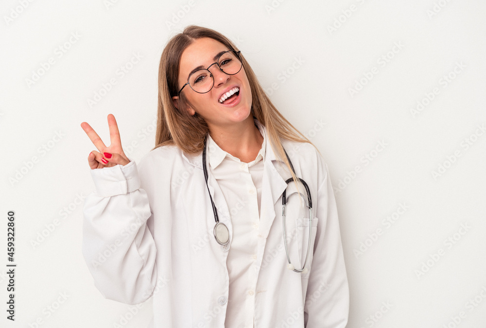 Young doctor Russian woman isolated on white background joyful and carefree showing a peace symbol with fingers. Young doctor Russian woman isolated on white background joyful and carefree showing a peace symbol with fingers.