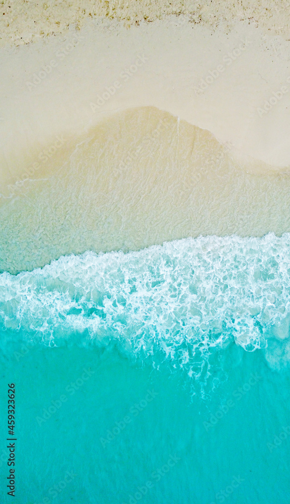 Top view of the beautiful ocean shore with waves and foam on the sand. Seychelles. Texture and background tourism design