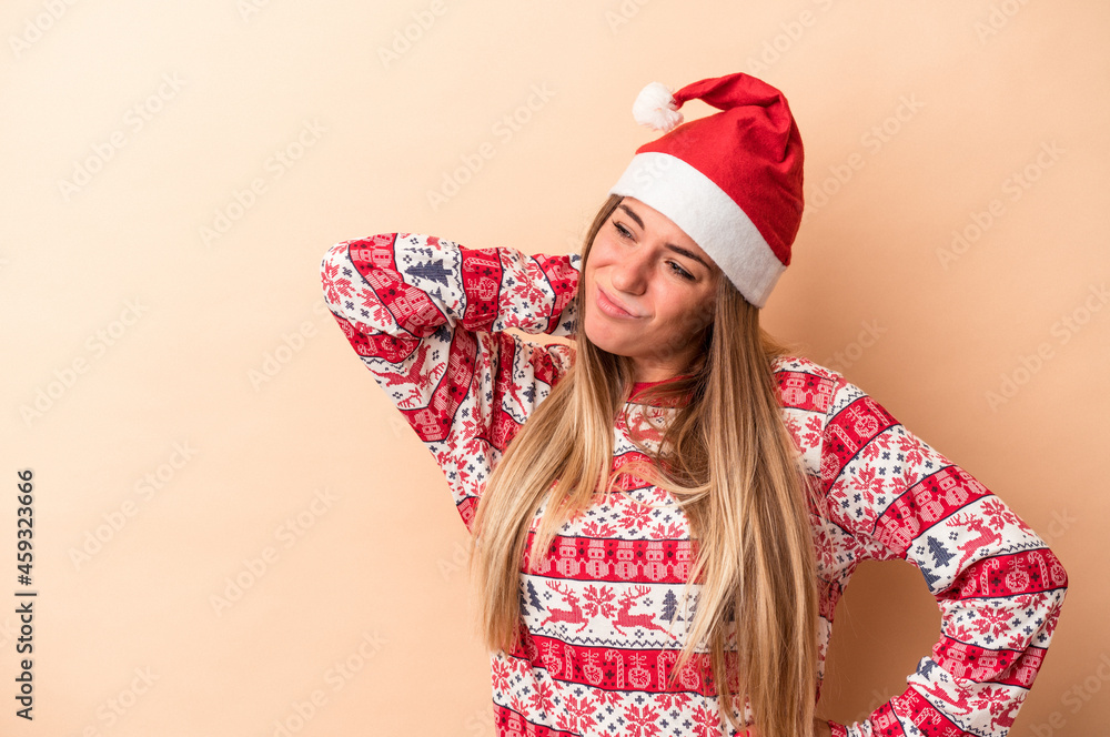 Young Russian woman celebrating Christmas isolated on beige background touching back of head, thinking and making a choice. Young Russian woman celebrating Christmas isolated on beige background touching back of head, thinking and making a choice.