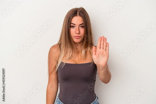 Young Russian woman isolated on white background standing with outstretched hand showing stop sign, preventing you.