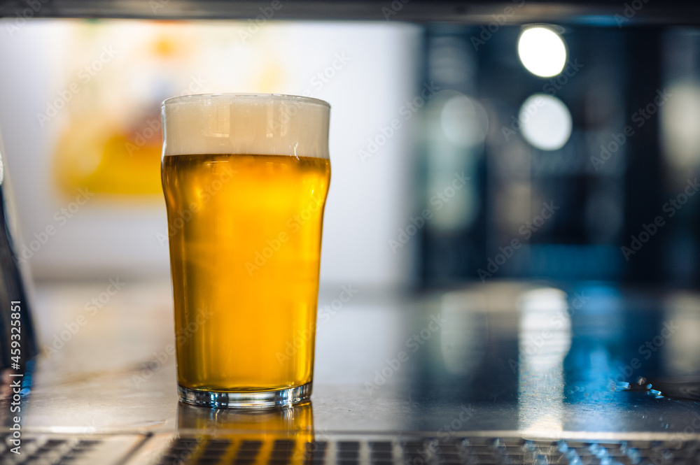 Cold beer glass on a bar or pub desk. Tasty fresh yellow beer of Czech Republic. Dark pub with nice bokeh on background. Cold beer glass on a bar or pub desk. Tasty fresh yellow beer of Czech Republic. Dark pub with nice bokeh on background.