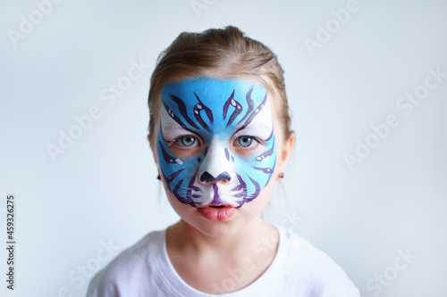 Girl aqua makeup in the form of a blue water tiger zodiac on a white background, concept symbol of the new year 2022, sad portrait. High quality photo