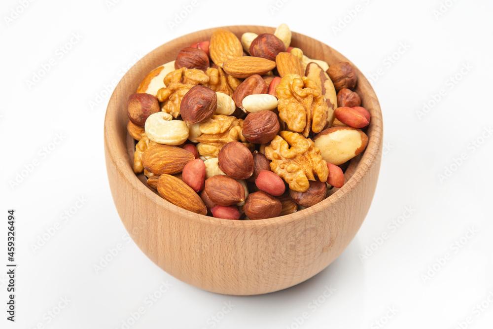 assortment of nuts in a wooden plate on a white background. vitamin organic food assortment of nuts in a wooden plate on a white background. vitamin organic food
