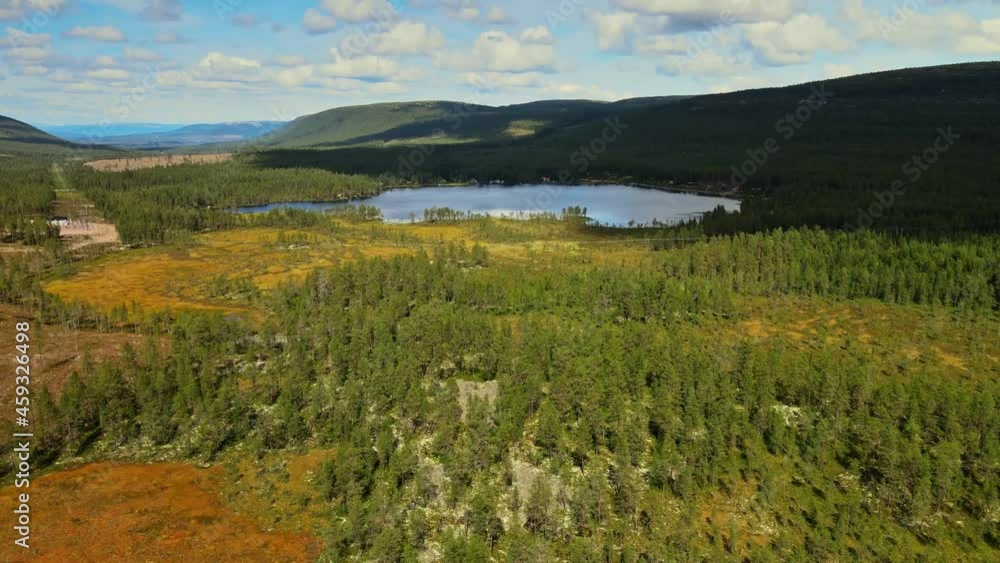 Verdant Trees On A Sunny Day Near Calm Lake With Mountain Views In Salen, Dalarna, Sweden. - aerial Verdant Trees On A Sunny Day Near Calm Lake With Mountain Views In Salen, Dalarna, Sweden. - aerial