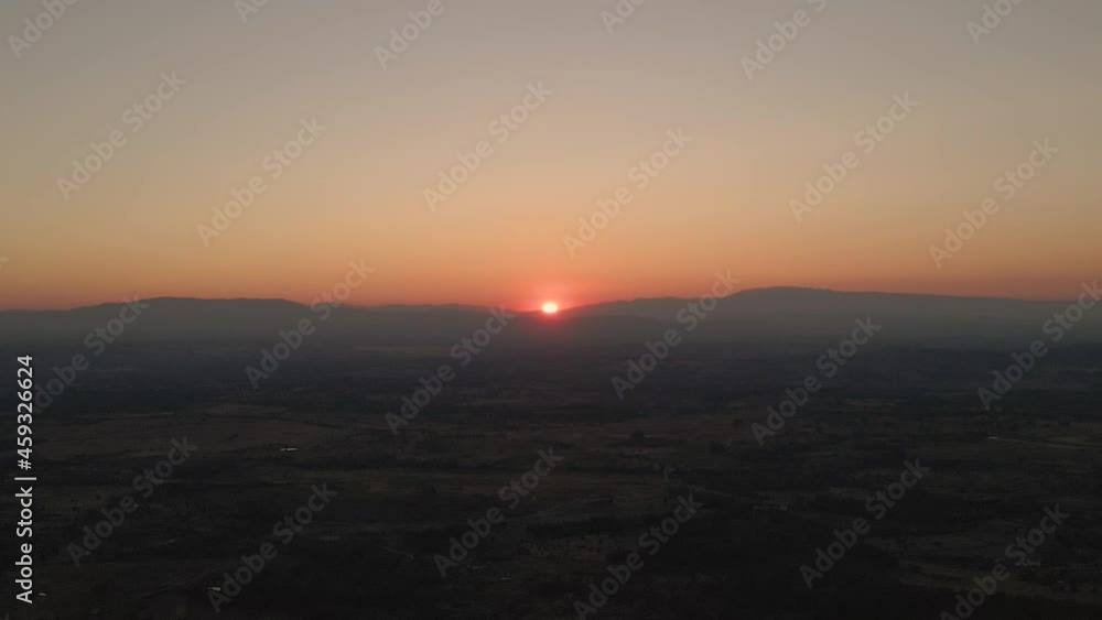 Sun disappearing on horizon over mountain at sunset, Monsanto in Portugal. Static view of sunset Sun disappearing on horizon over mountain at sunset, Monsanto in Portugal. Static view of sunset