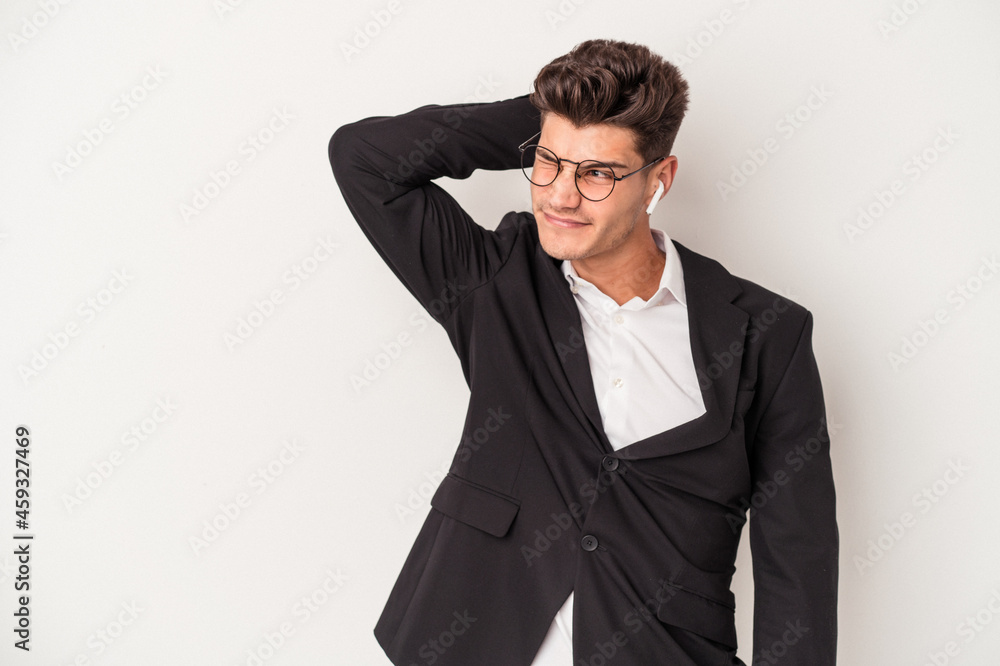 Young business caucasian man wearing headphones isolated on white background touching back of head, thinking and making a choice. Young business caucasian man wearing headphones isolated on white background touching back of head, thinking and making a choice.