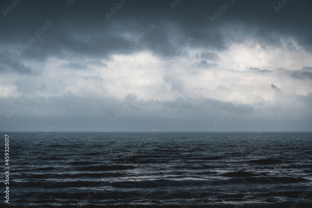 Obraz premium Melancholic dark blue seascape with silver shining waves during storm