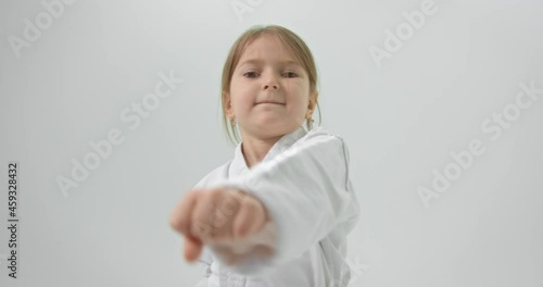 The little girl is engaged in zarate on their own. The girl is preparing to defeat her opponent with strong blows. photo