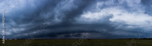 A rain front is approaching over a small private airfield. Panoramic shot.