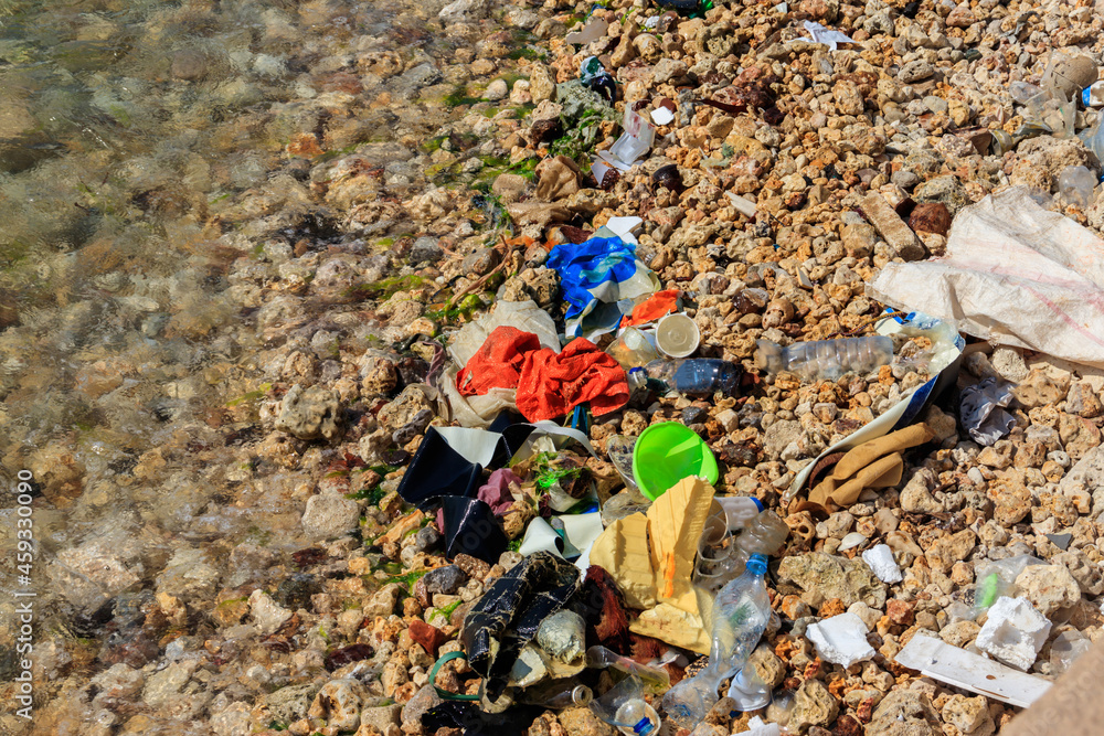 Garbage on a bank of ocean. Pollution of sea, ocean water with waste, plastics garbage. Concept of pollution of ocean, sea and river coastline with plastic trash Garbage on a bank of ocean. Pollution of sea, ocean water with waste, plastics garbage. Concept of pollution of ocean, sea and river coastline with plastic trash