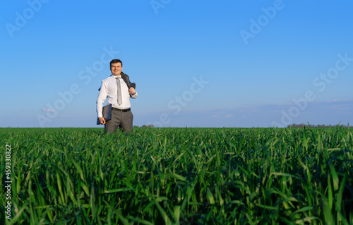 businessman works in a green field  freelance and business concept  green grass and blue sky as background