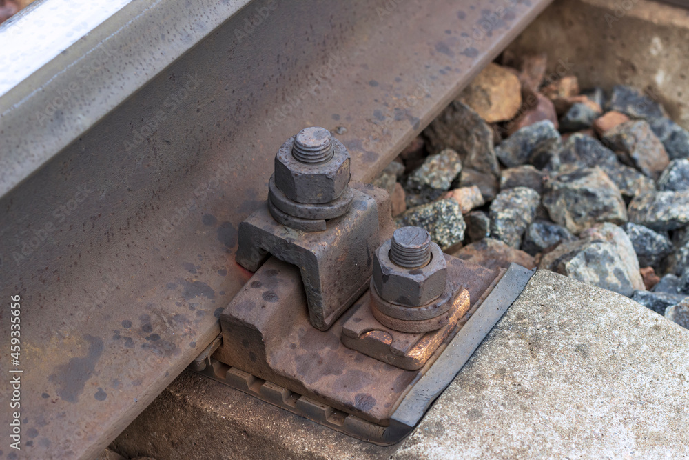 Bolts that attach railway rails to concrete sleepers. Railway fasteners in close-up. Bolts that attach railway rails to concrete sleepers. Railway fasteners in close-up.