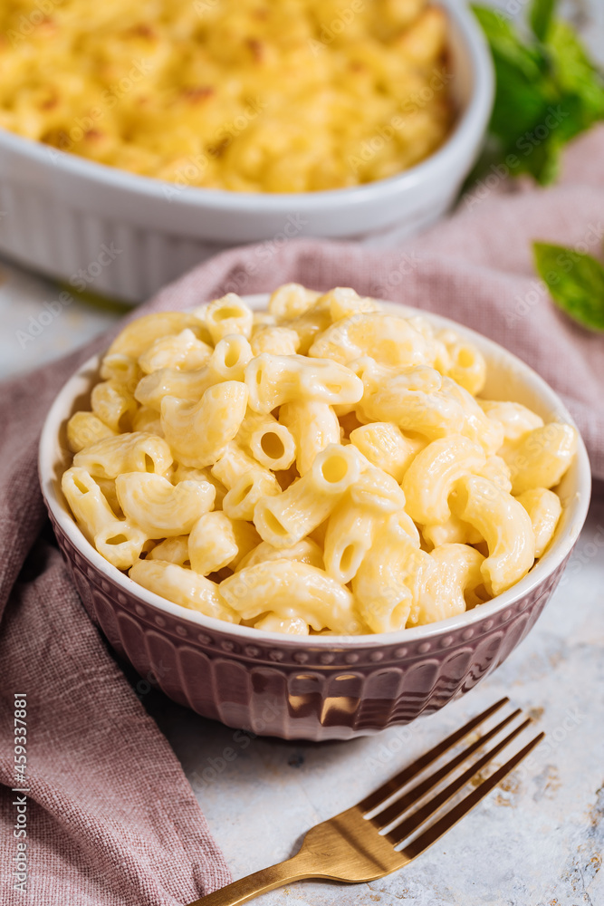 Mac and cheese with basil on top on a rustic wooden board Mac and cheese with basil on top on a rustic wooden board