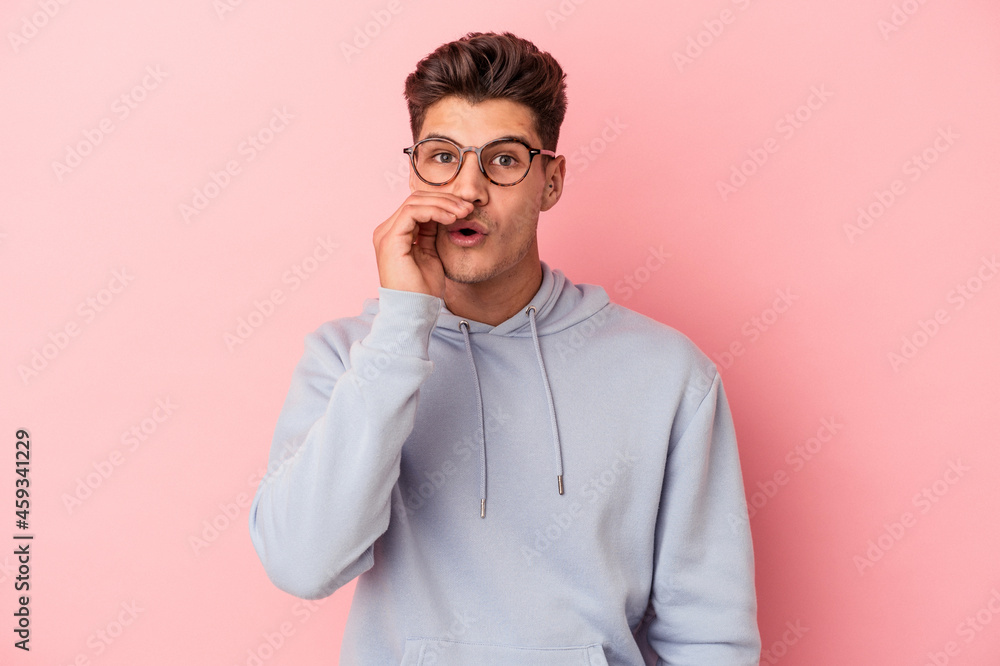 Young caucasian man isolated on pink background is saying a secret hot braking news and looking aside Young caucasian man isolated on pink background is saying a secret hot braking news and looking aside