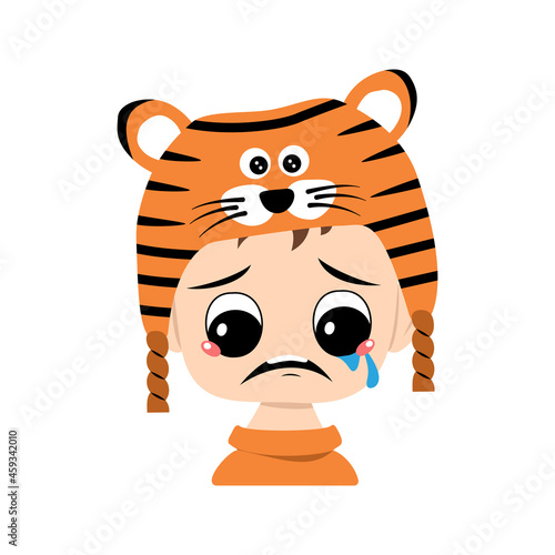 Boy with big eyes and depressive emotion, crying, tears face in tiger hat. Cute kid with sad face in a festive costume for New Year, Christmas and holiday. Head of adorable child with emotions