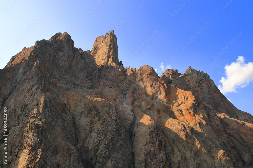 The rocks of the mountain against the blue sky. Suitable for interior, photo wallpapers, photo frames and lovers of mountain landscapes.