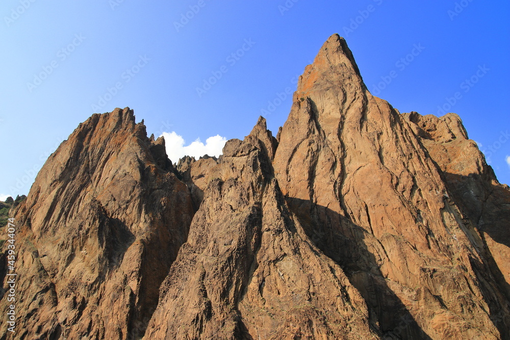 The rocks of the mountain against the blue sky. Suitable for interior, photo wallpapers, photo frames and lovers of mountain landscapes. The rocks of the mountain against the blue sky. Suitable for interior, photo wallpapers, photo frames and lovers of mountain landscapes.
