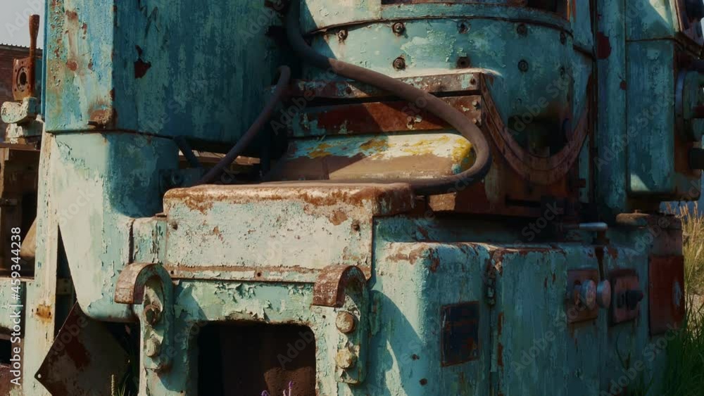 An old rusty machine with paint flying off in places is in a dump in the open air, waiting to be recycled into metal. Industrial collapse and bankruptcy concept. An old rusty machine with paint flying off in places is in a dump in the open air, waiting to be recycled into metal. Industrial collapse and bankruptcy concept.
