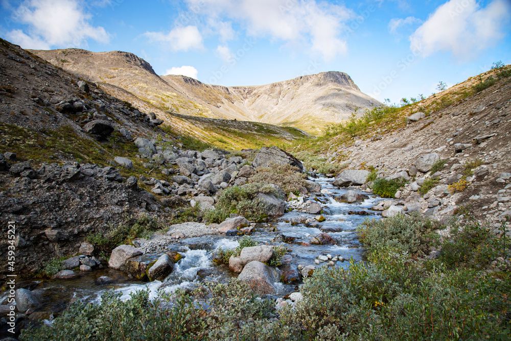 landscape of the Khibiny mountains with rocks and a mountain stream on a sunny day. Kola Peninsula, Russia