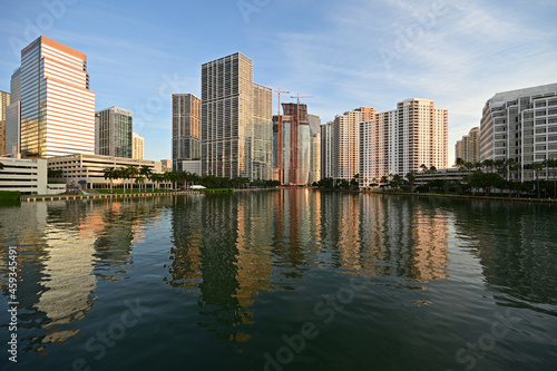 City of Miami, Florida skyline reflected in still water of Biscayne Bay at sunrise.