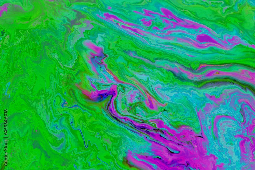 Abstract pink-green marble background. Acrylic paint mixes freely and creates an interesting pattern. Bright saturated shades. Background for the cover of a laptop, book.