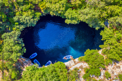 Famous tourist attraction. Aerial drone view of iconic cave with Melissani Lake near Sami village, Kefalonia island, Greece