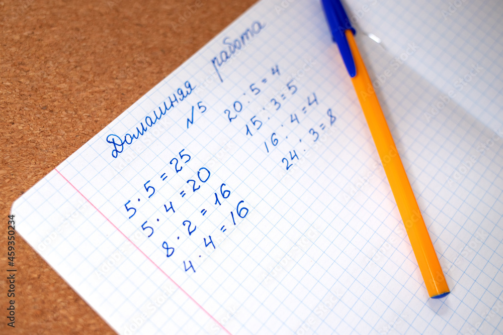 Equation in a notebook of a Russian student, elementary school, simple arithmetic, notebook in a cage for lessons Equation in a notebook of a Russian student, elementary school, simple arithmetic, notebook in a cage for lessons