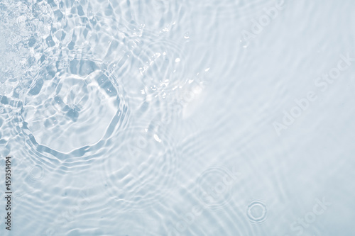 Light blue water background with circles from drops and stains all over the surface
