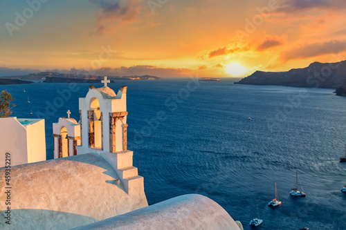 Iconic Greek picture. Beautiful sunset with famous Orthodox church on Santorini island, Aegean sea, Greece.