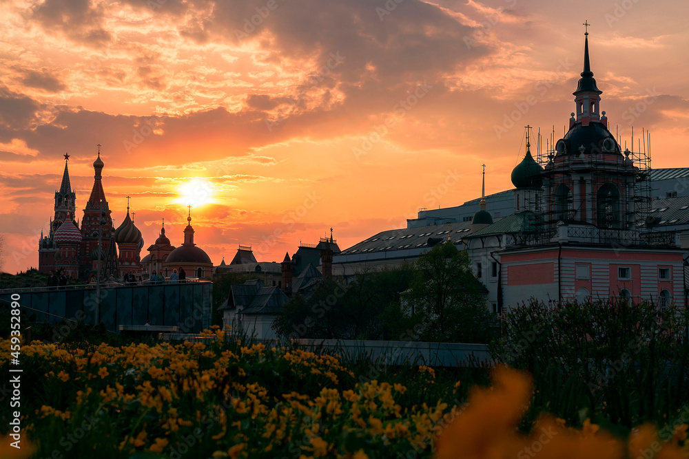 Flowers in the zaryadye park against the saint basil's cathedral and the sun in the sky at summer sunset