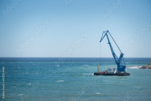 Marine crane on the blue sea water background.