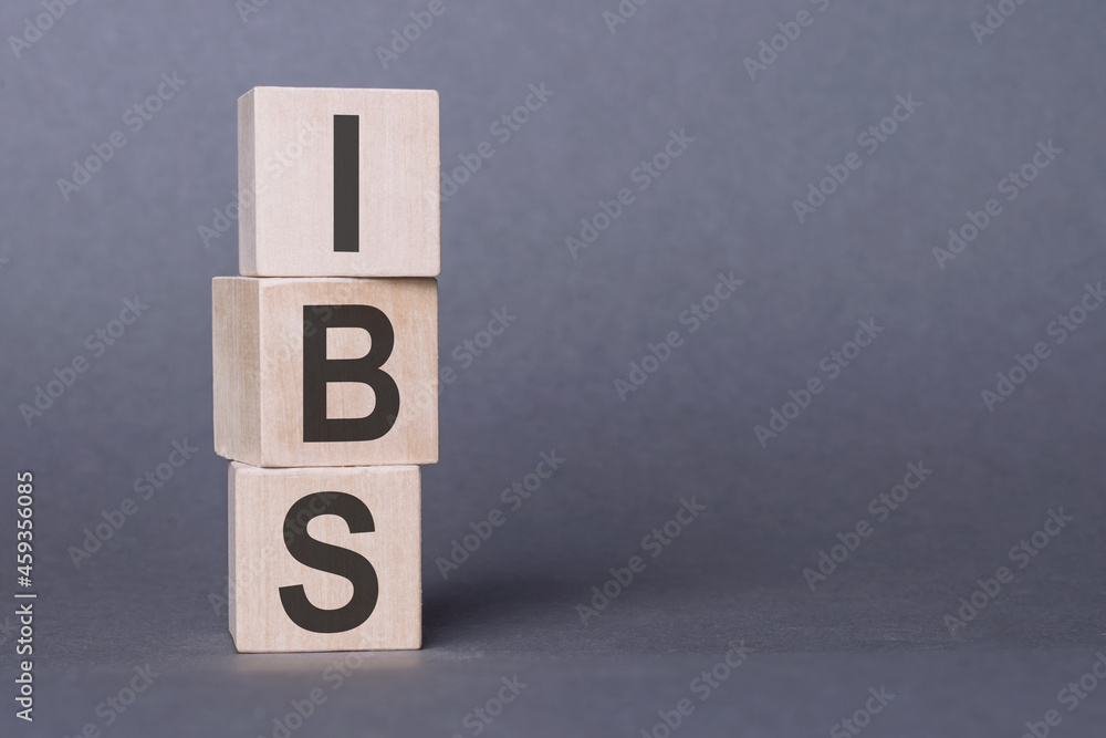 IBS - Irritable Bowel Syndrome, text written on wooden blocks, on gray background. IBS - Irritable Bowel Syndrome, text written on wooden blocks, on gray background.