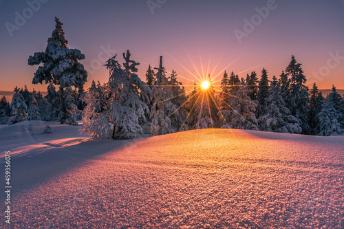 Beautiful winter sunset with sunstar at the mountain photo