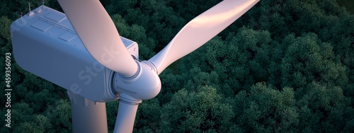 Close up of wind turbine with lush forest in the background.  photo